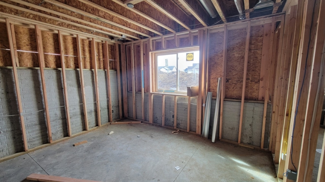A room under construction with wood framing and insulation, highlighting Happe Homes' new listings at 2912 NW Beechwood Ct, Ankeny, IA