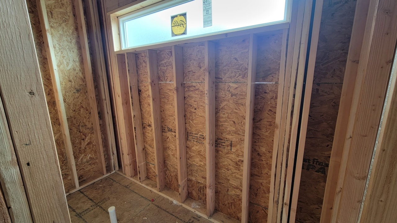 Bright bathroom with wood framing and a window, showcasing Happe Homes for sale at 2912 NW Beechwood Ct, Ankeny, IA