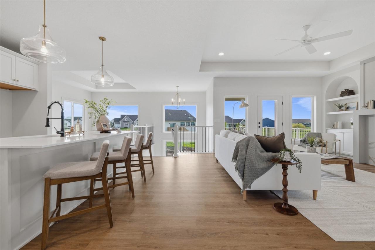 Wide open-concept living room and kitchen with large windows and neighborhood views in Ankeny Iowa new home