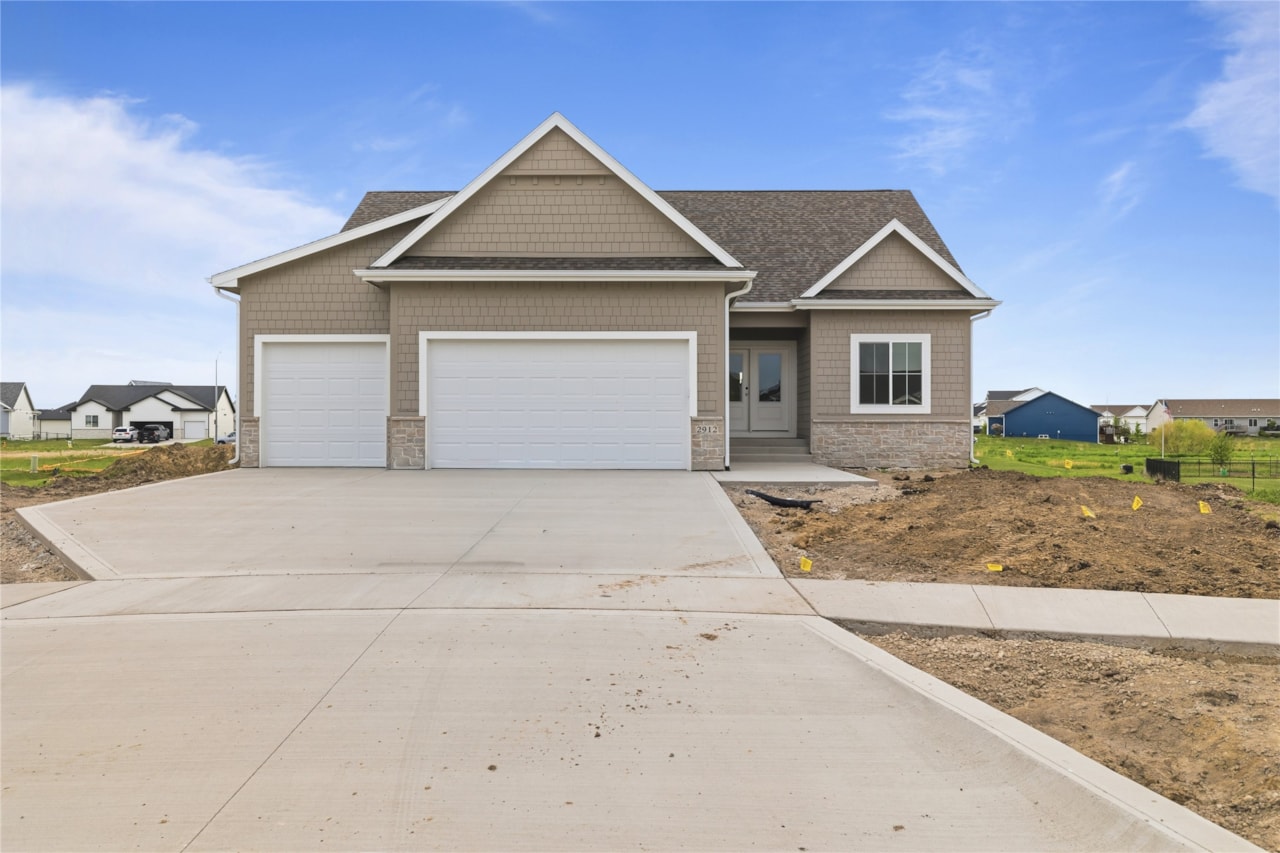Front exterior of new construction craftsman-style home with three-car garage in Ankeny, Iowa