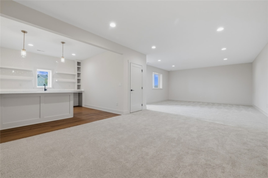 Spacious finished lower level rec room with wet bar, carpet, and recessed lighting in Ankeny Iowa new construction