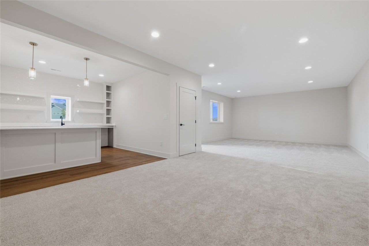 Spacious finished lower level rec room with wet bar, carpet, and recessed lighting in Ankeny Iowa new construction