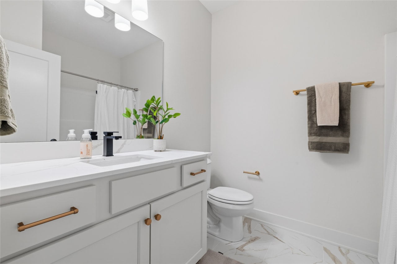 Lower Level Full Bathroom with White Vanity and Gold Accents – New Home in Ankeny, IA | Happe Homes
