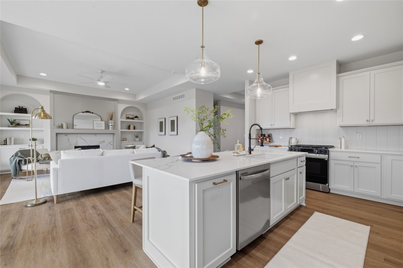 Open floor plan kitchen and living room with fireplace and built-in shelving in new Ankeny Iowa home
