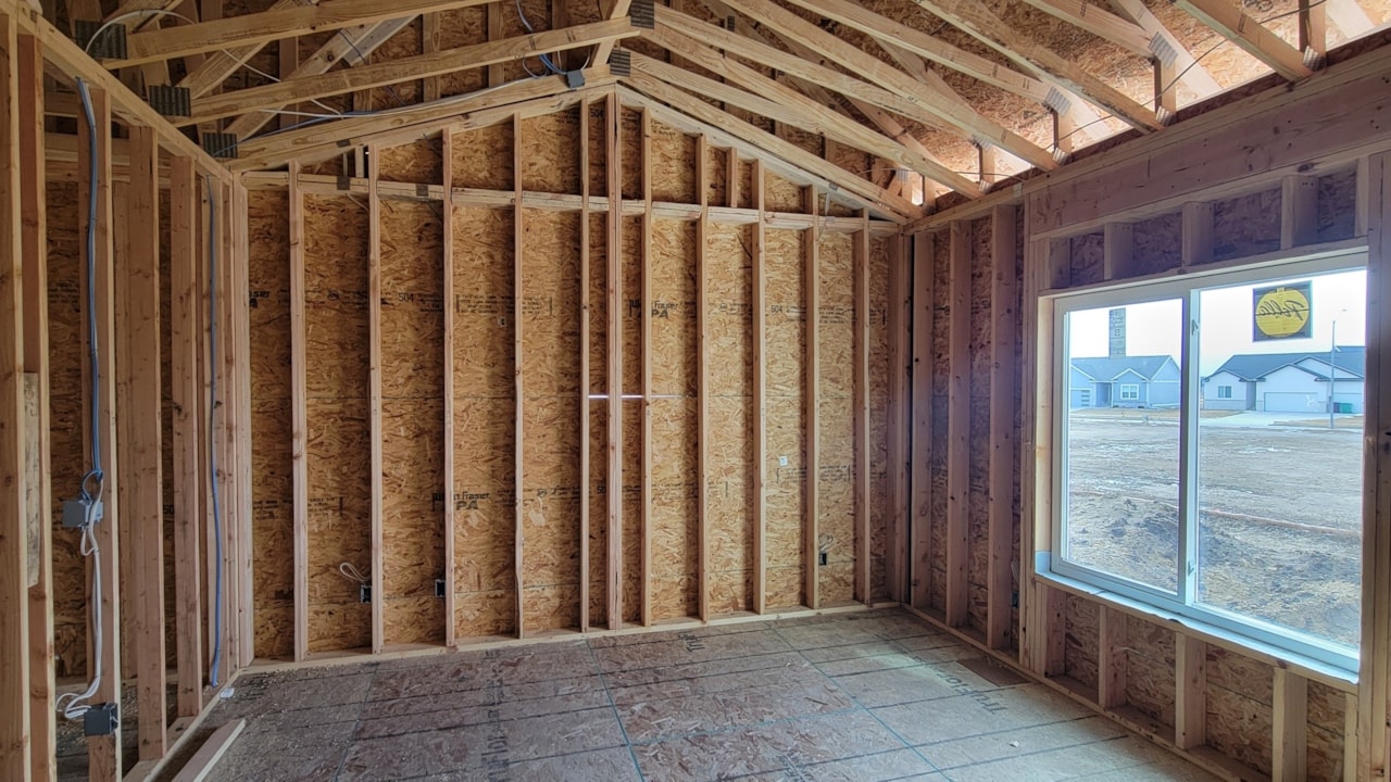 Room featuring wood framing and windows, showcasing Happe Homes' available move-in ready homes in Ankeny, IA